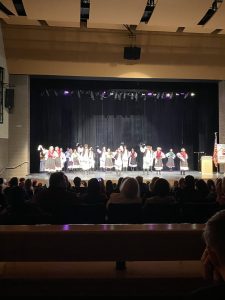Dancers in colorful folk costumes performing a kolo across the whole stage.