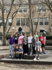 Students gathered for a group photo by Meštrović's bronze sculptures on the Notre Dame campus.